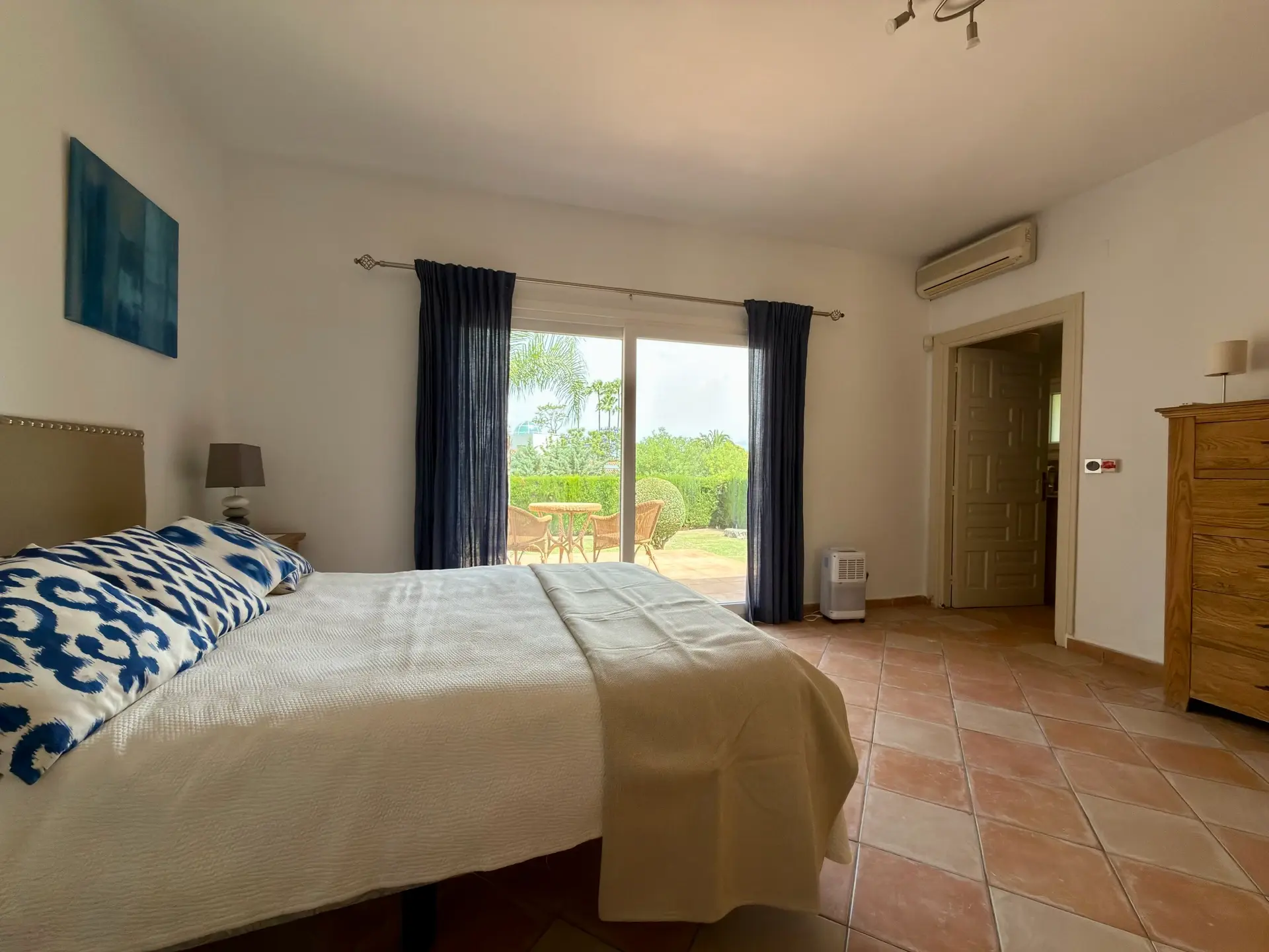 Bedroom with double bed, garden doors and terracotta flooring