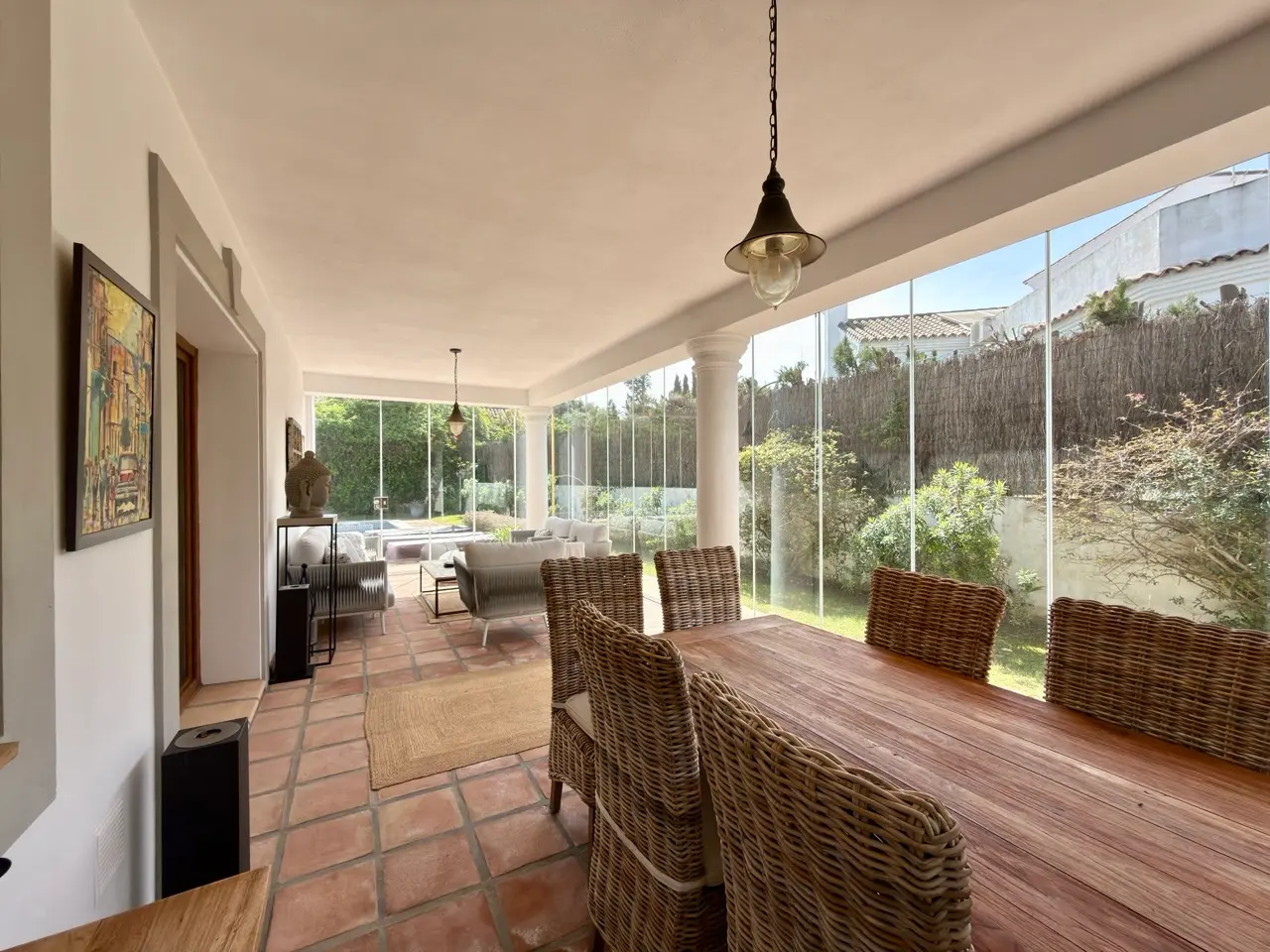 Covered terrace with outdoor dining area and garden views