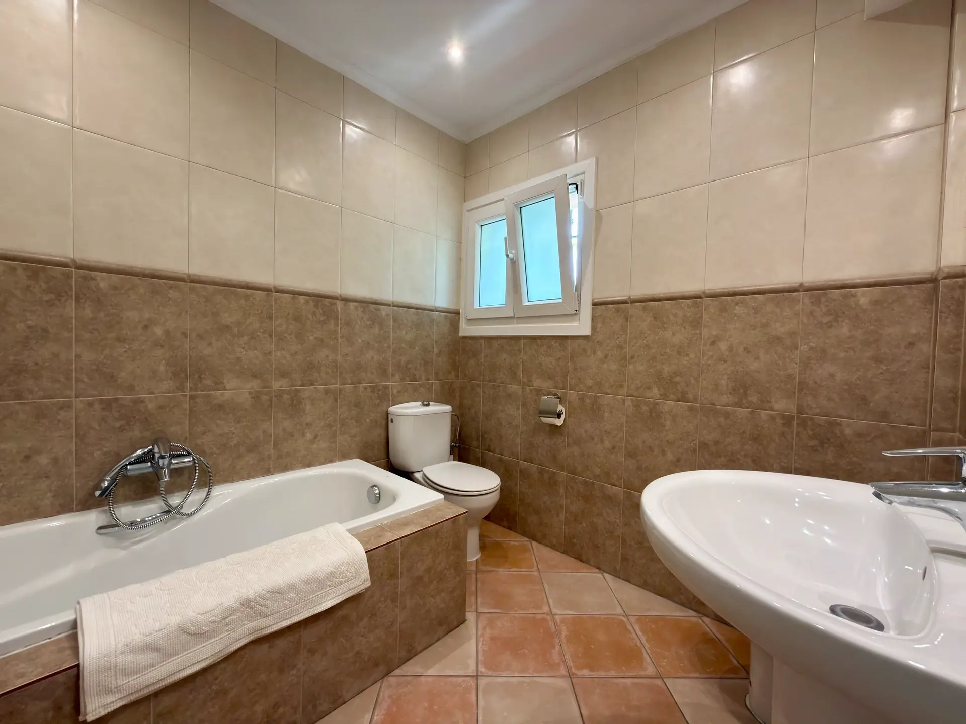 Bathroom with bathtub, bidet and tiled walls
