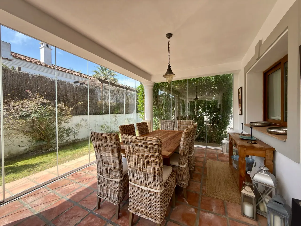 Covered terrace with outdoor dining table and garden views