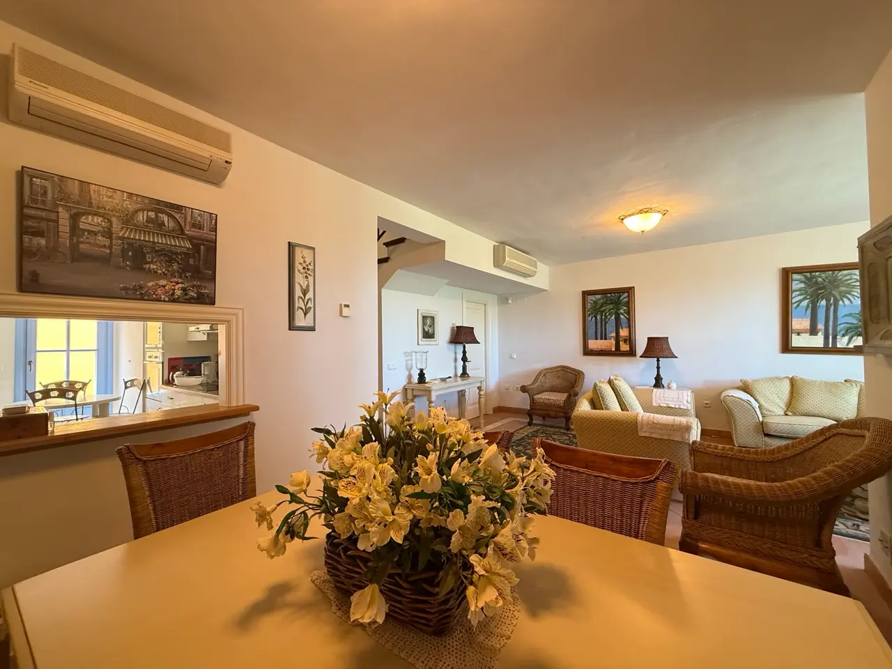 Living and dining area with sofa seating and warm lighting