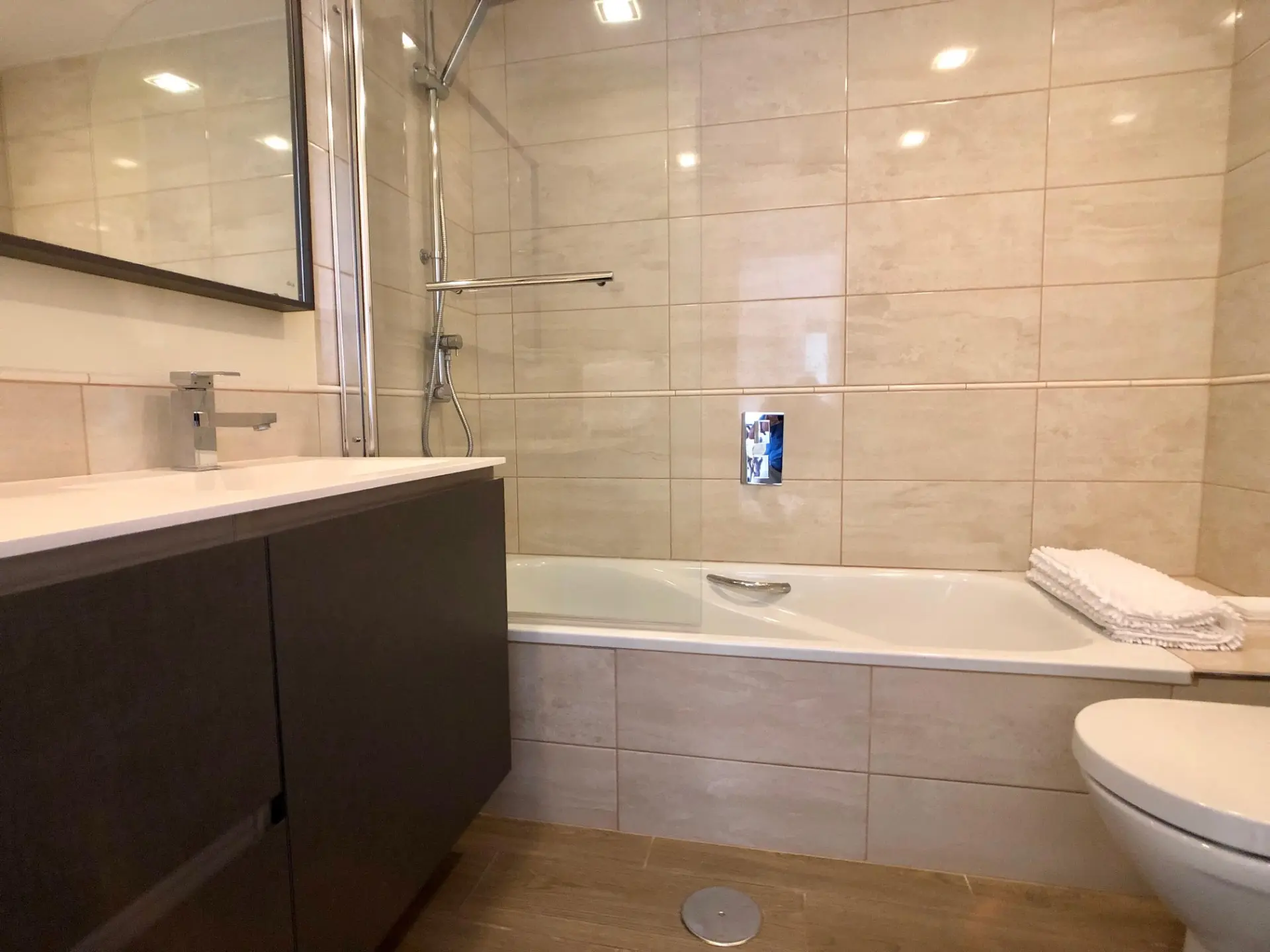 Baño con bañera, mueble de lavabo y mampara de cristal