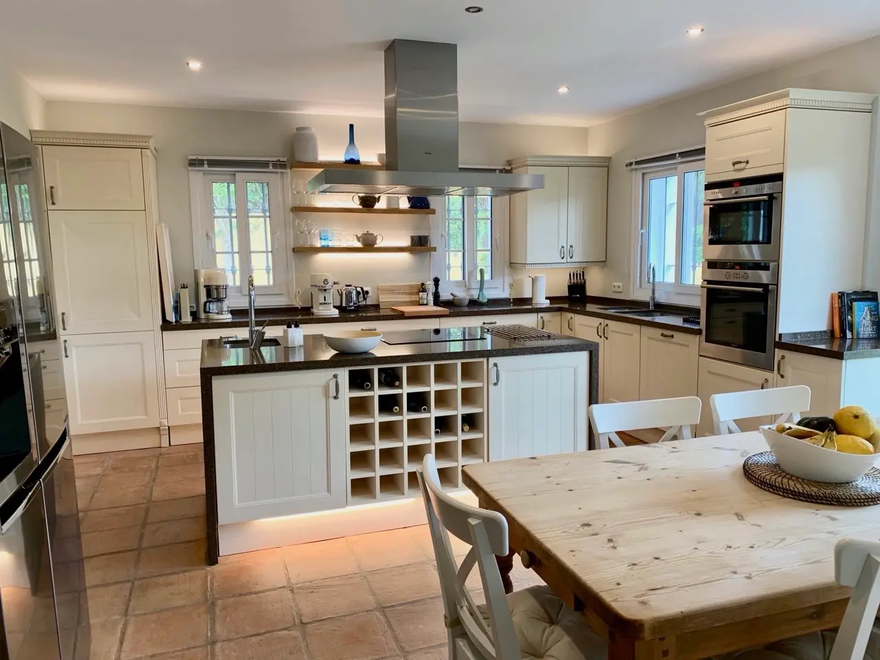Kitchen with central island, wine rack and garden-facing window