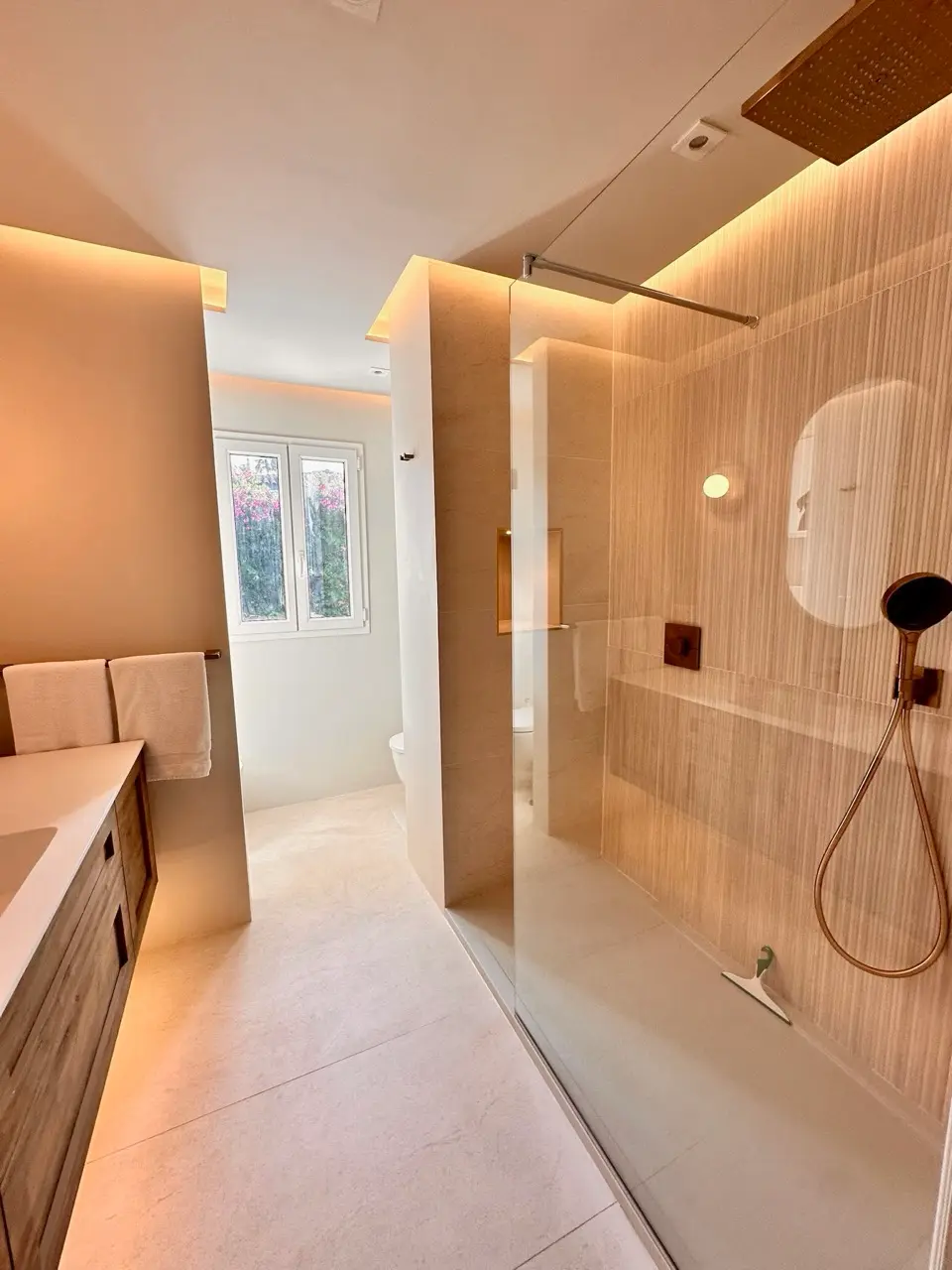 Bathroom with walk-in shower, vanity and soft indirect lighting