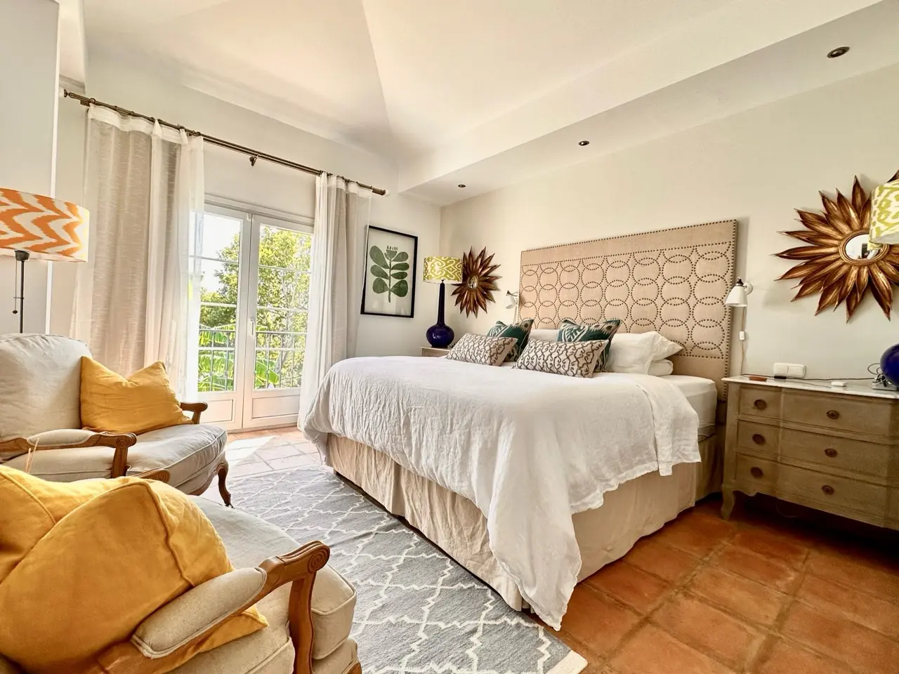 Bedroom with double bed, upholstered headboard and natural light