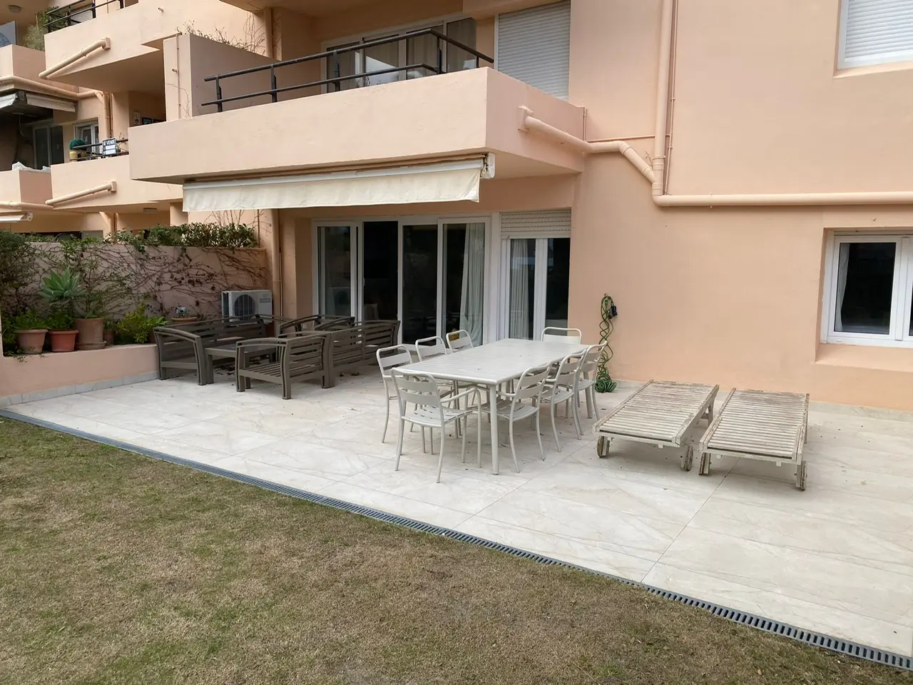 Exterior de apartamento en planta baja con terraza con asientos y zona de jardín
