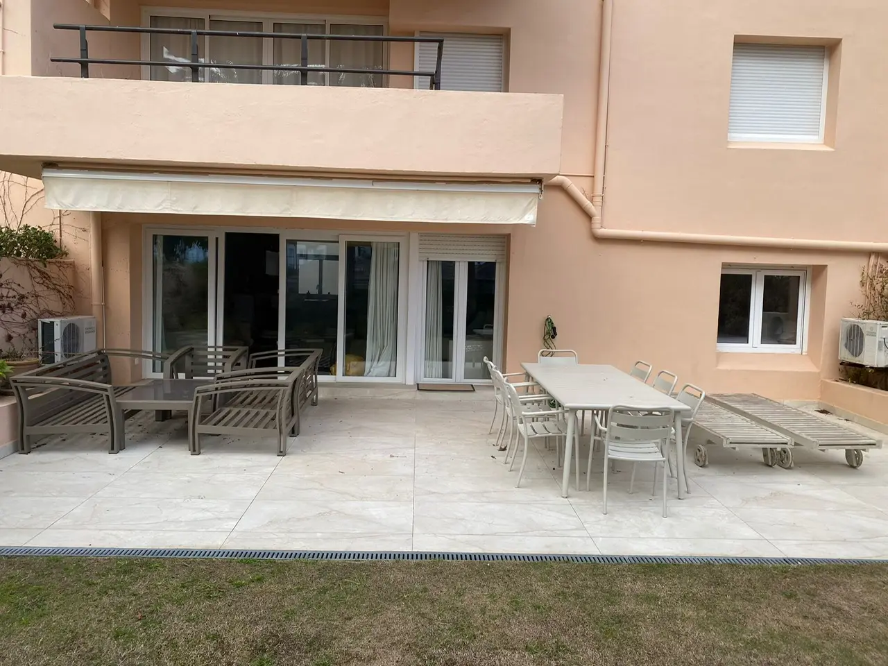 Terraza en planta baja con asientos exteriores y exterior del apartamento