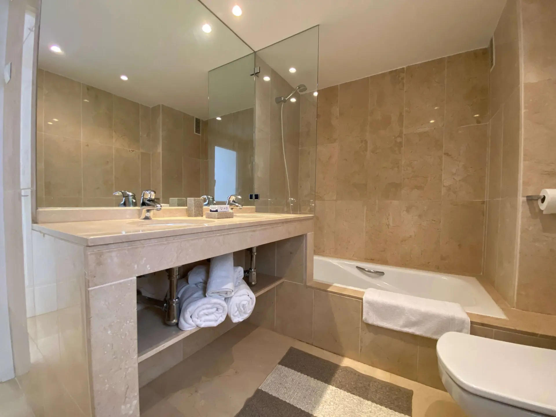 Bathroom with bathtub, vanity unit and tiled walls