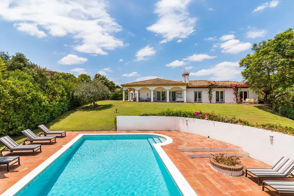 Swimming pool with sun loungers, terrace and villa exterior