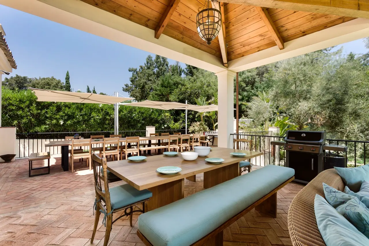 Salón con vigas de madera vistas, sofás y acceso a la terraza