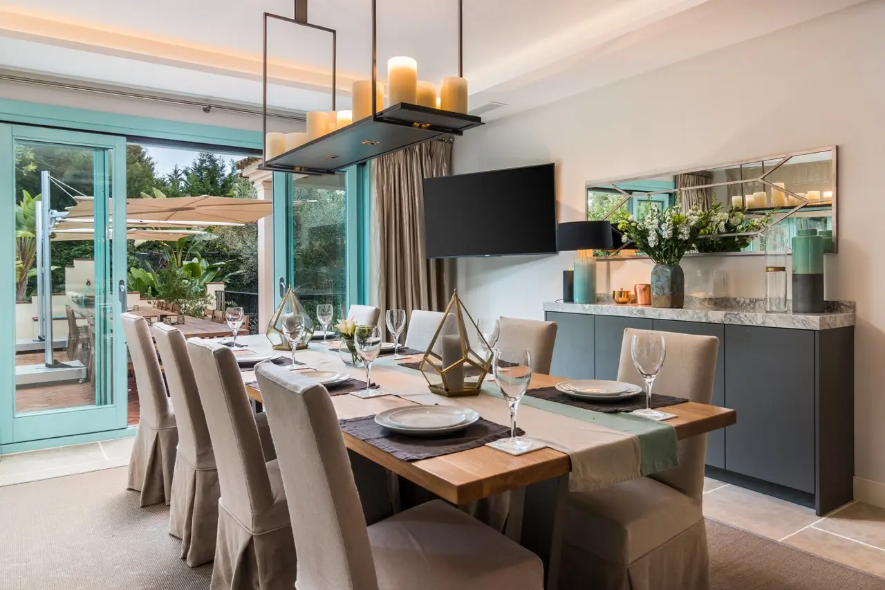 Comedor con mesa alargada, acceso a la cocina y puertas a la terraza