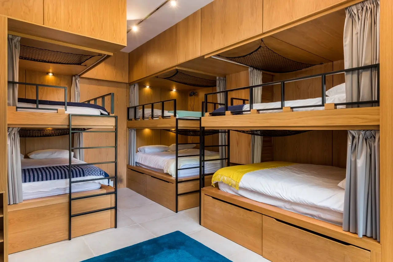 Dormitorio con literas de madera y suelo azul