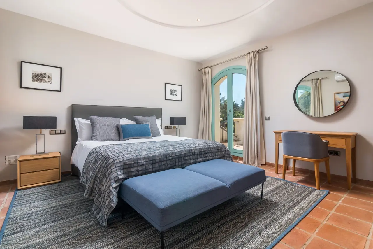 Dormitorio con cama doble, zona de estar y acceso a la terraza