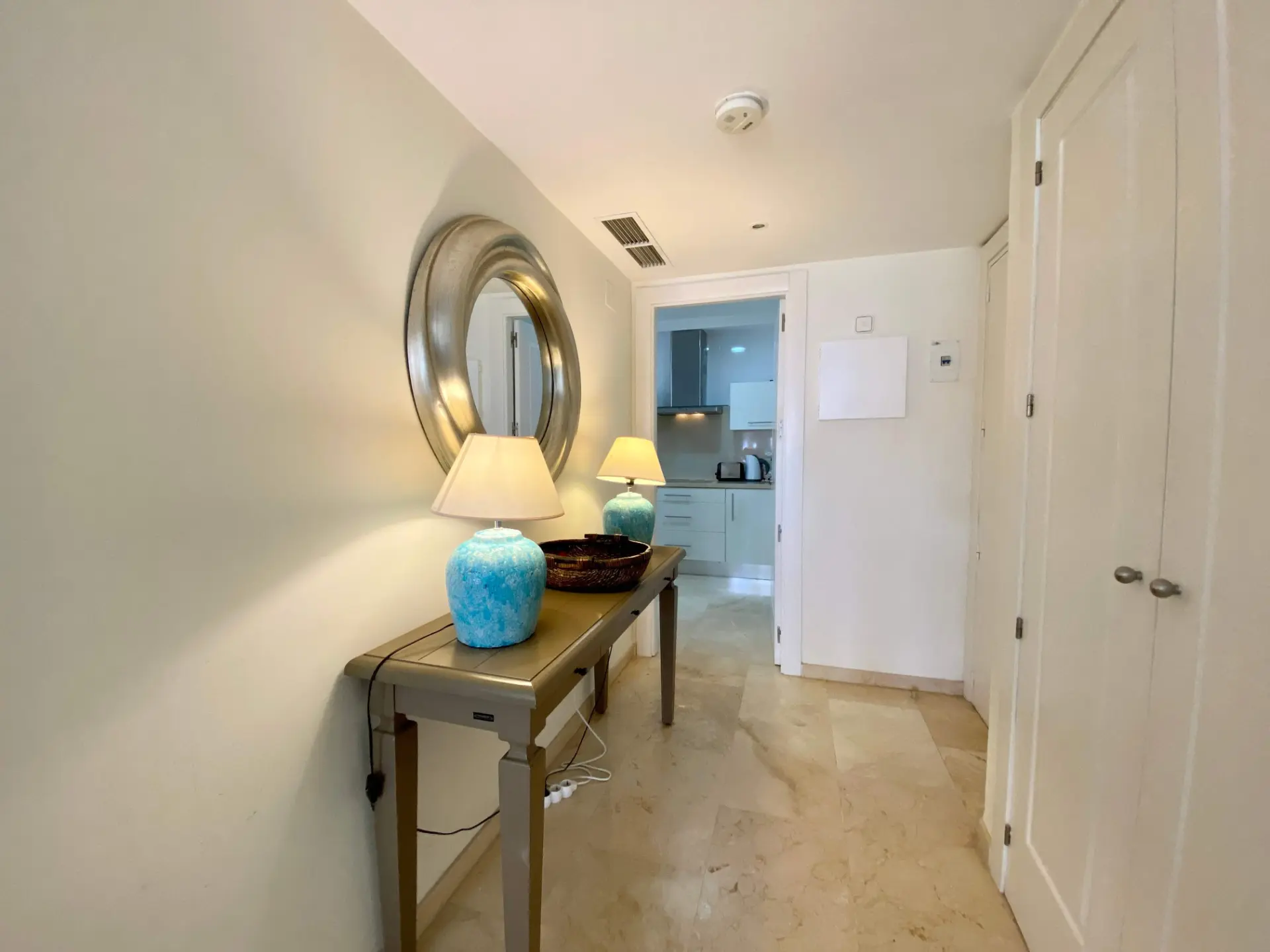 Hallway with console table, round mirror and bedroom access