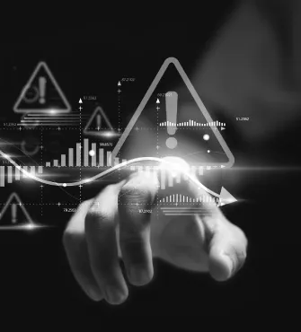 Hand pointing towards a glowing digital warning icon with data charts and graphs overlay.