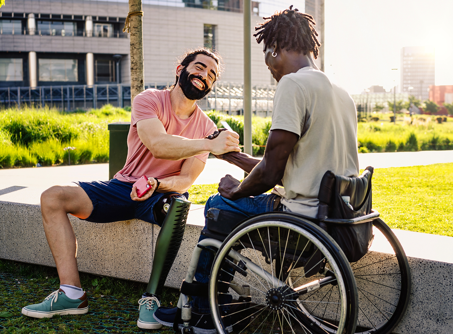 Two disabled men meeting each other outside in a sunny park 