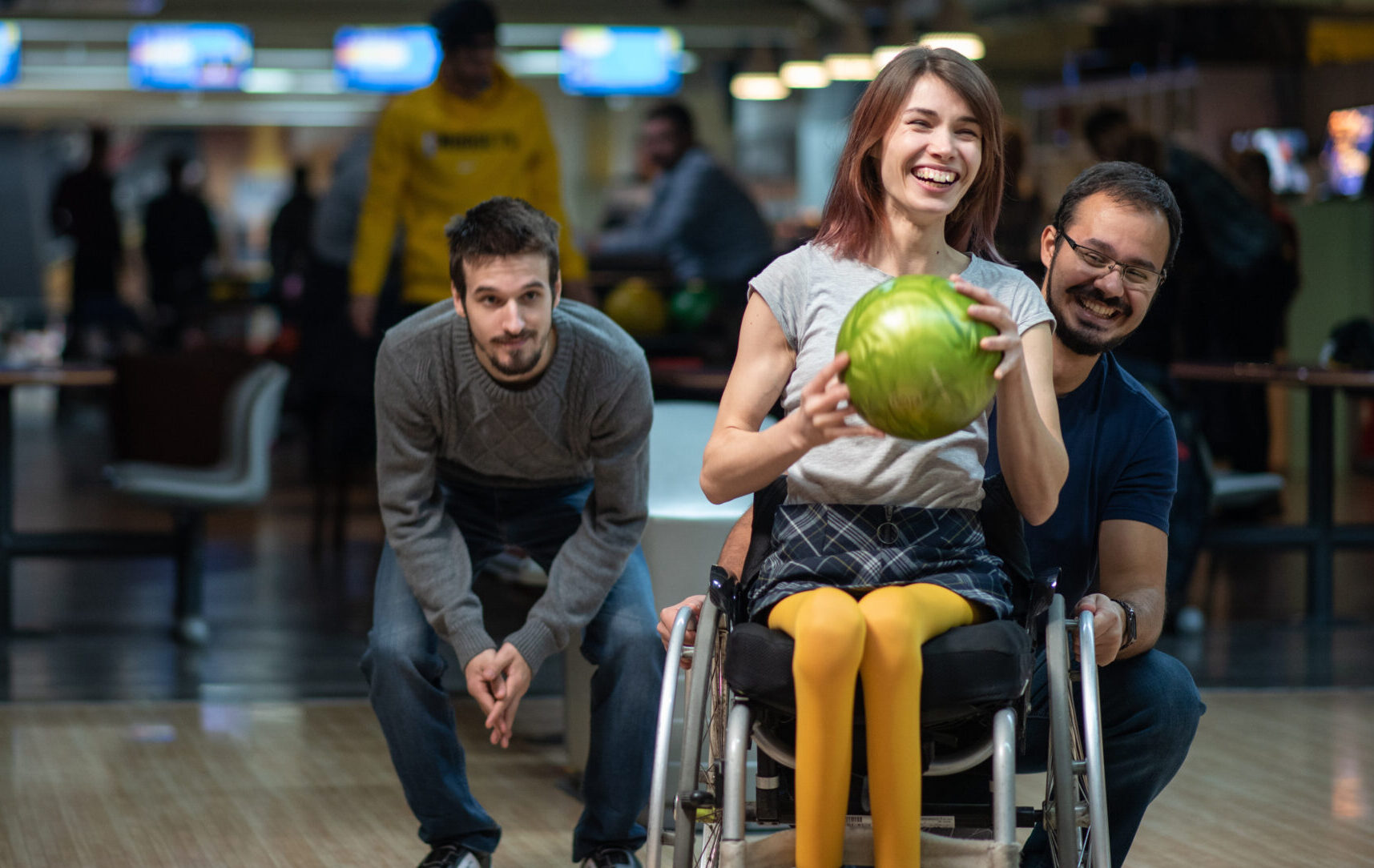 Woman in a wheelchair bowling with her friends