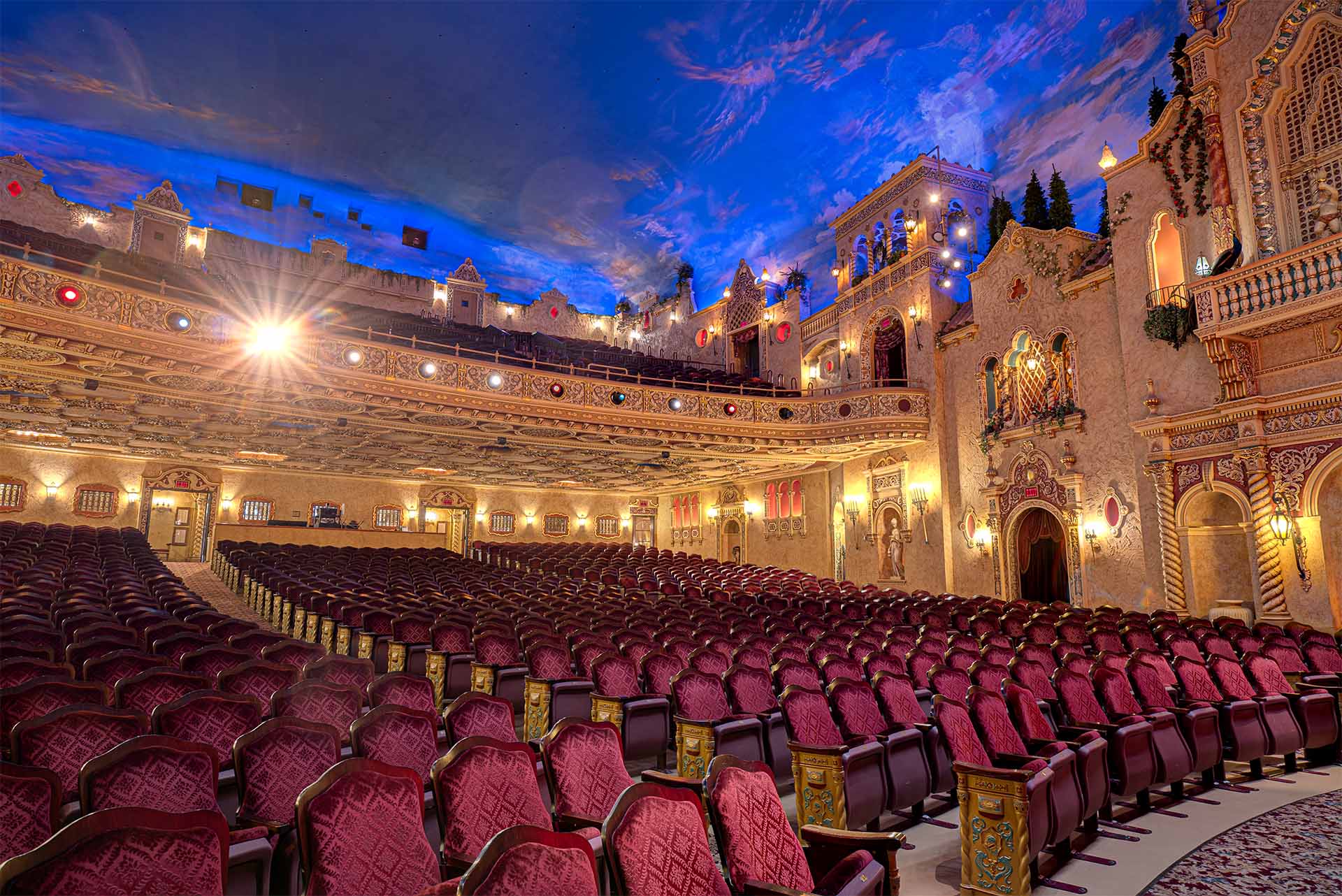 The Paramount Theatre auditorium with red velvet seats, detailed gold decor, and a painted sky ceiling.