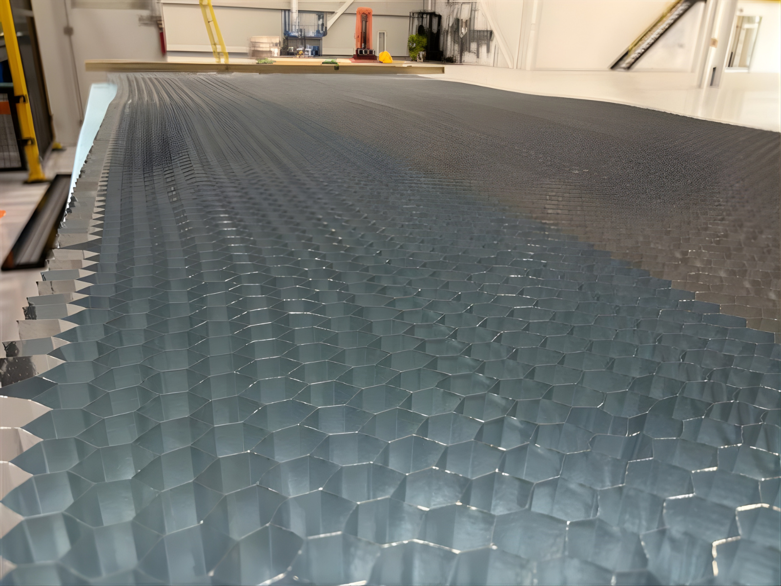 Close-up of a large metallic honeycomb panels in an industrial workshop.