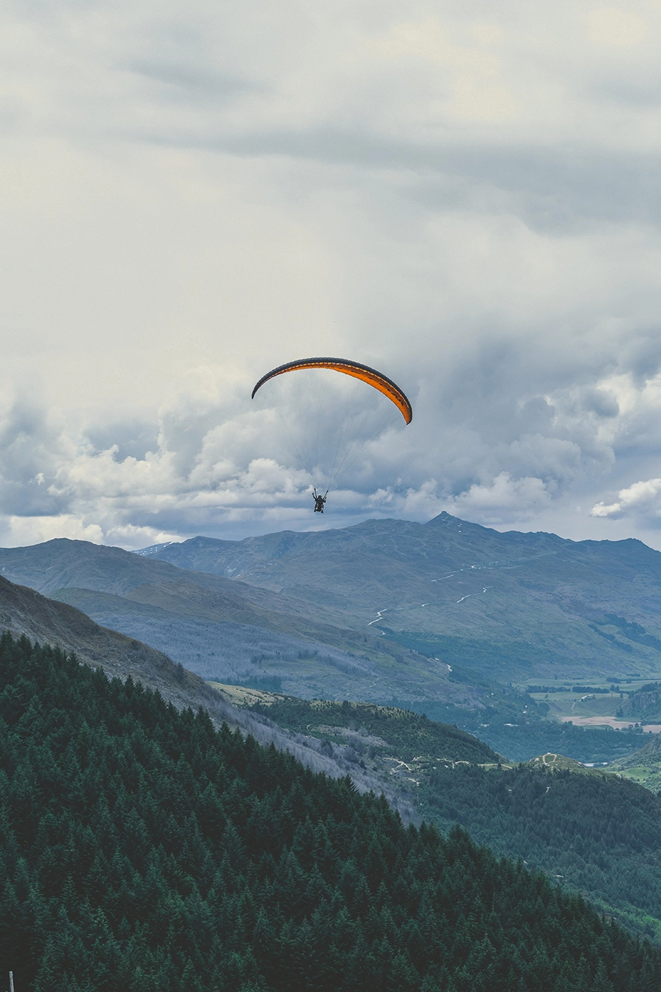 Person paragliding over the mountains.