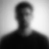 Blurred grayscale image of a person against a light background.