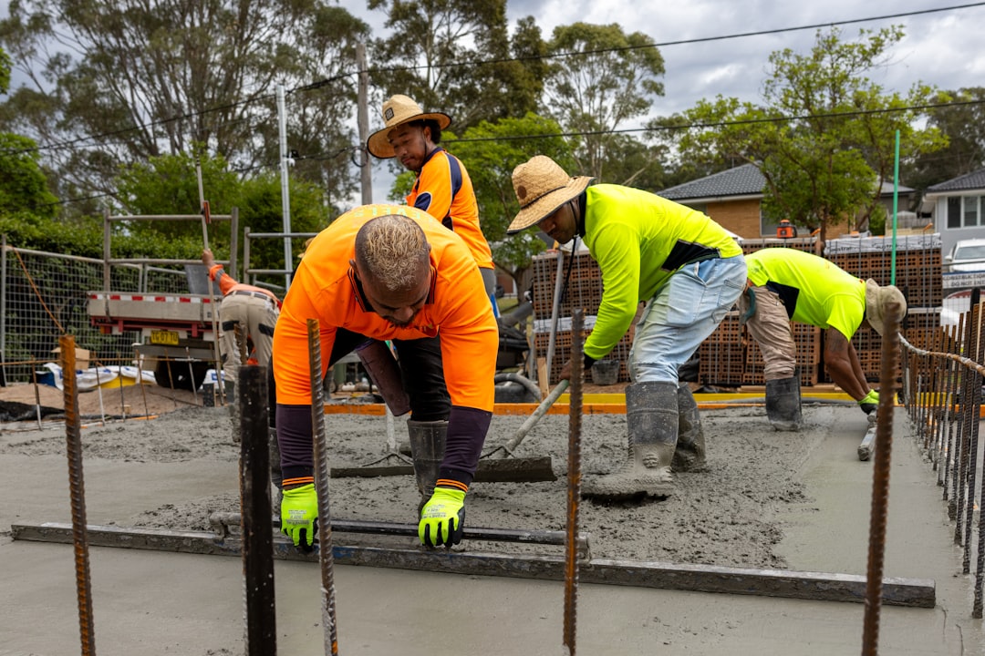 concrete crew smoothing a freshly poured driveway slab - concrete driveway contractor