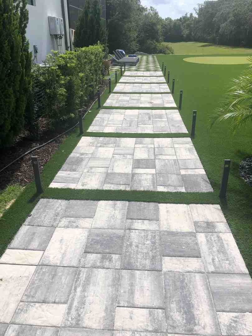 flexible plastic edging being installed along a curved walkway - cheap paver edging ideas