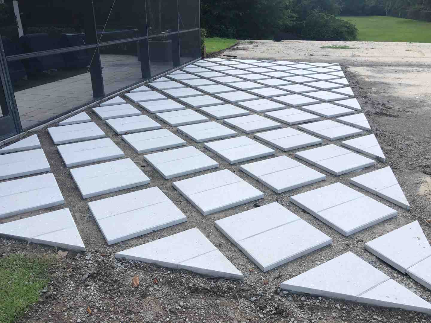 professional installer using a plate compactor on a gravel base - professional paver installation