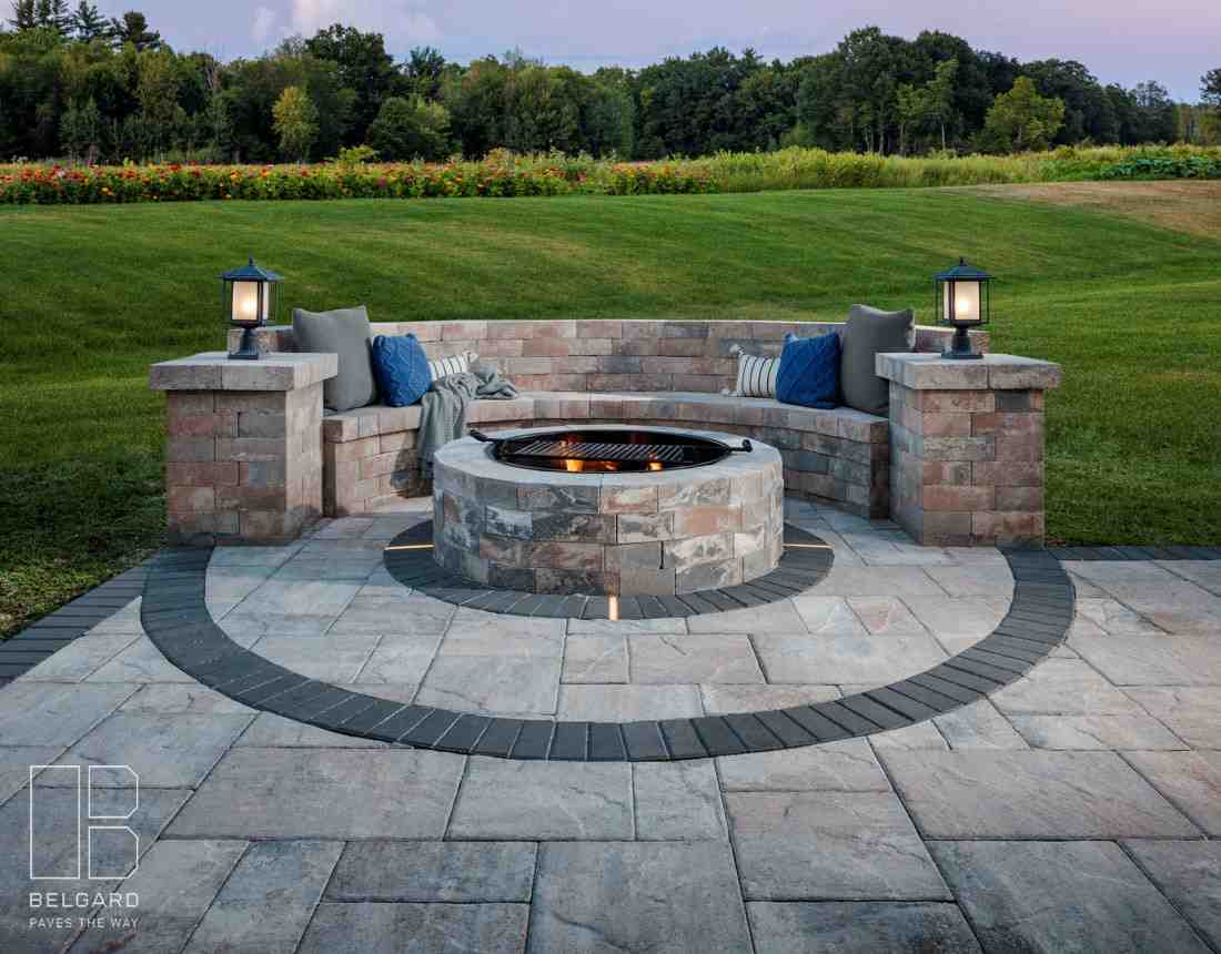 A circular fire pit with a curved seating wall providing ample guest seating - how seating walls enhance your patio or fire A circular fire pit with a curved seating wall providing ample guest seating - how seating walls enhance your patio or fire