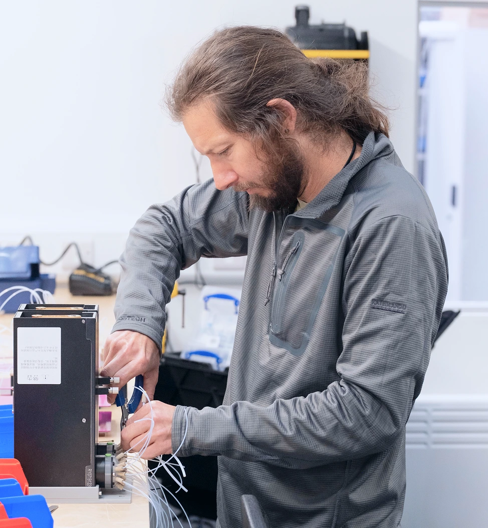 Technician repairs a robotic chemistry instrument