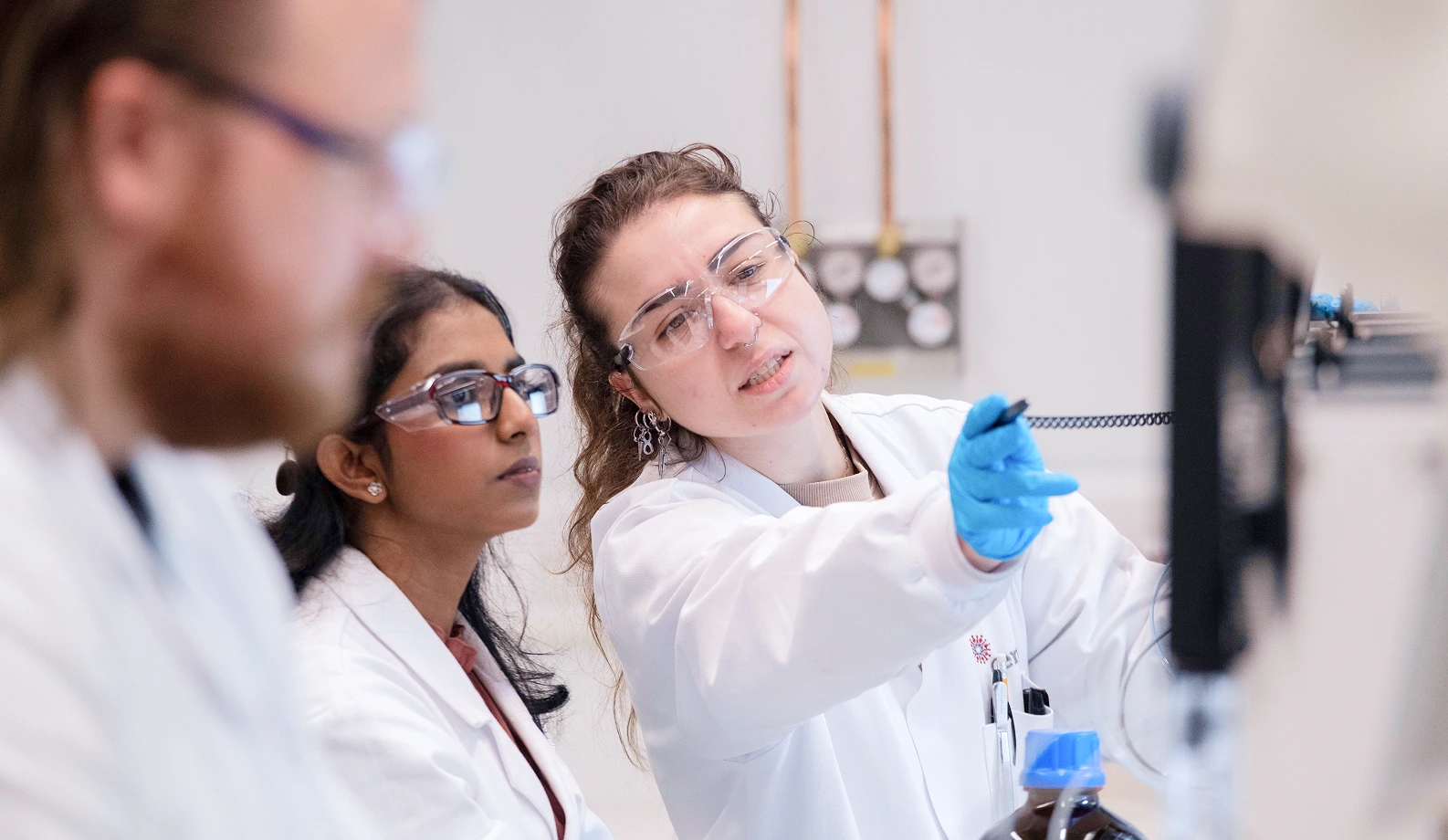 Scientist in a chemistry lab points out something to a colleague