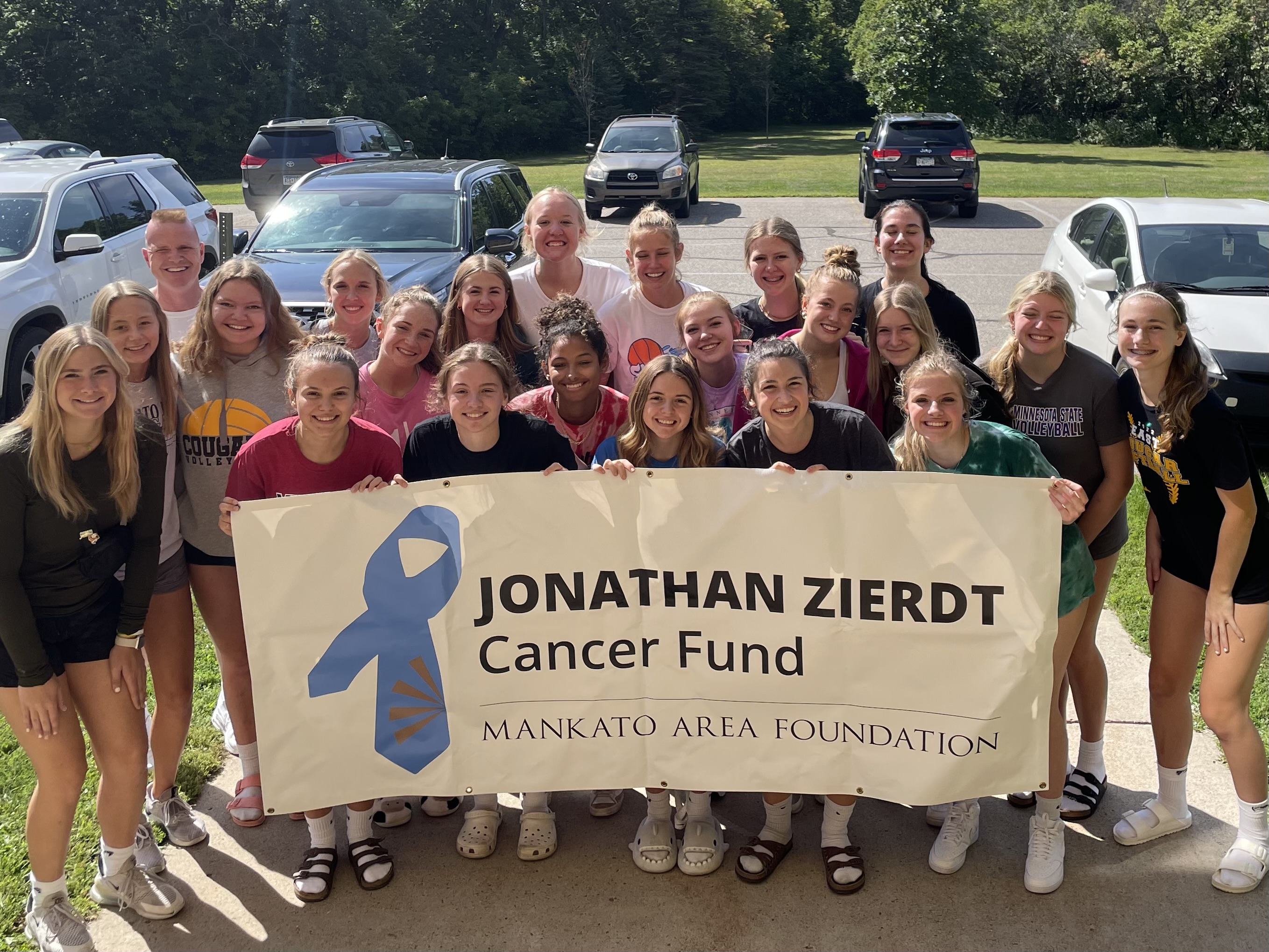A group of volunteers holding a JZ Cancer Fund Sign