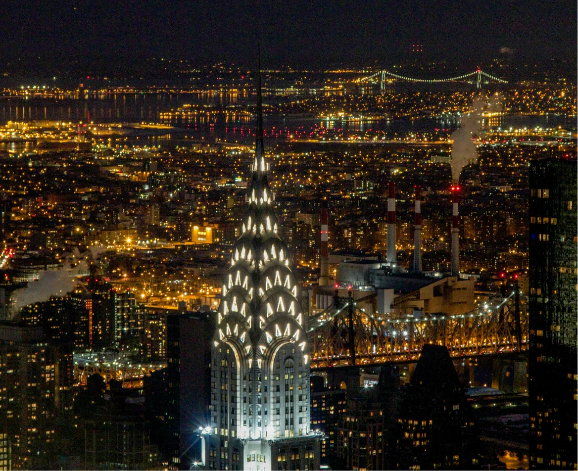 New York City skyline illuminated at night, marking the return of the Pan Am journey to its point of departure.
