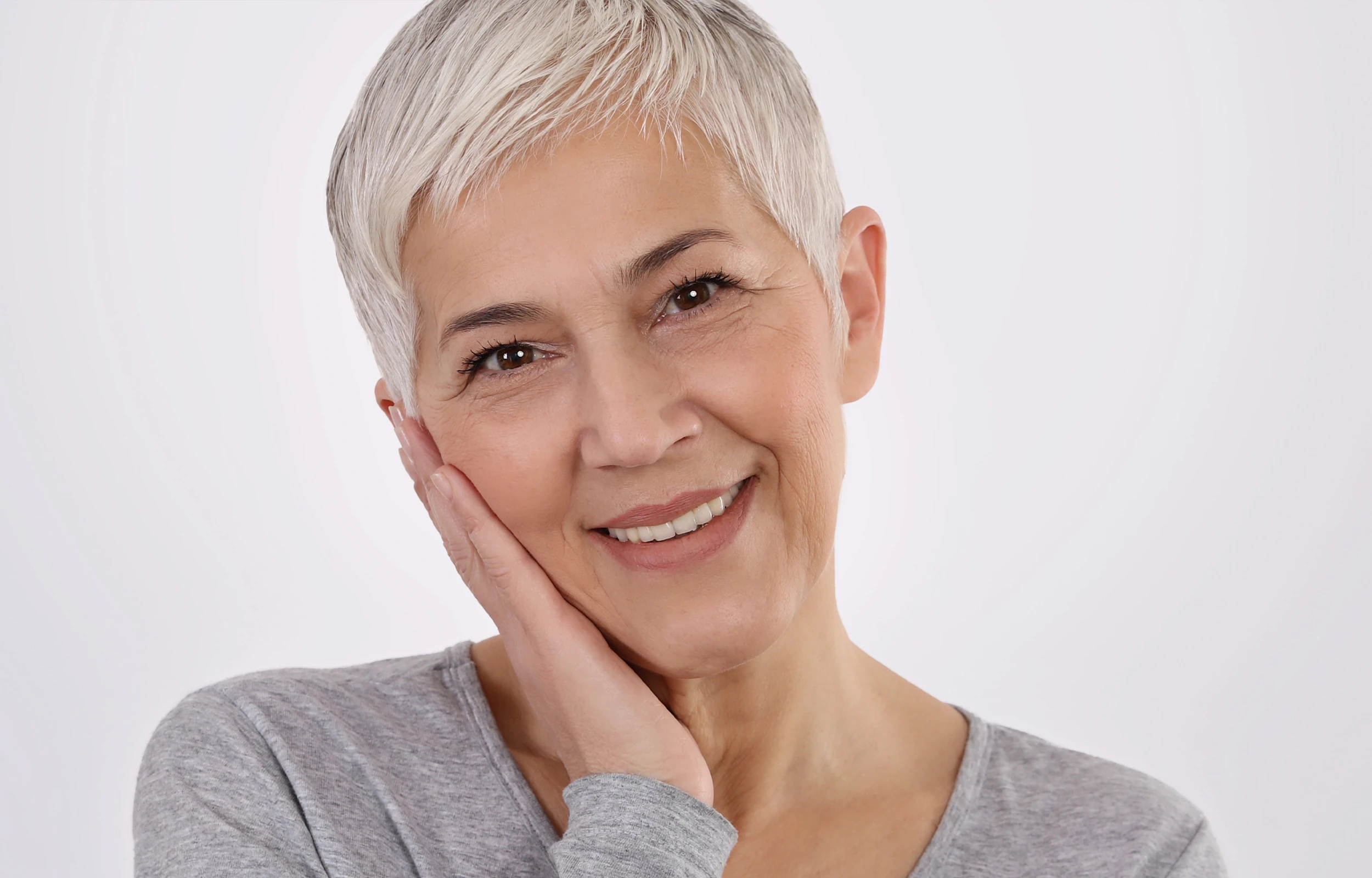 A woman smiling with her hand on her face