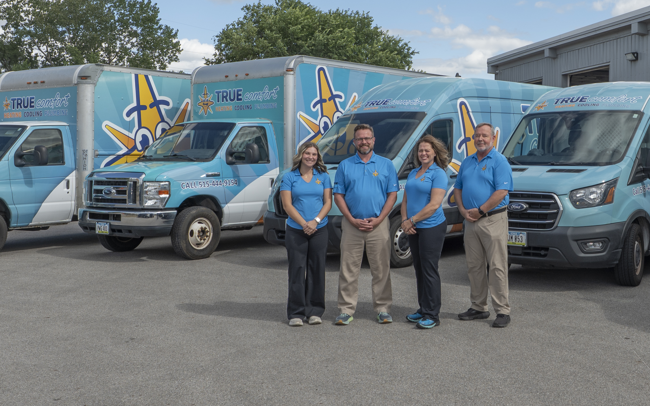 True Comfort team stands in front of their service vans, ready to provide heating, cooling, and plumbing solutions.

