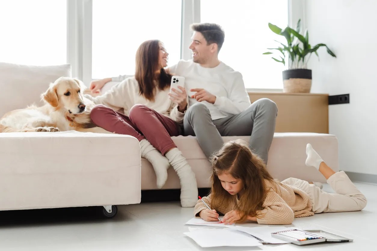 Family of three with a golden retriever in a modern living room
