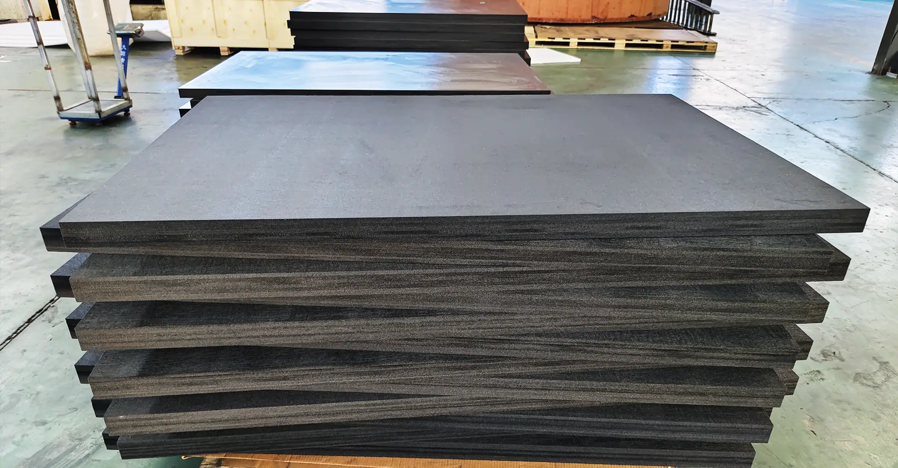 A pile of graphite felt board sitting on Max Graphite's factory floor