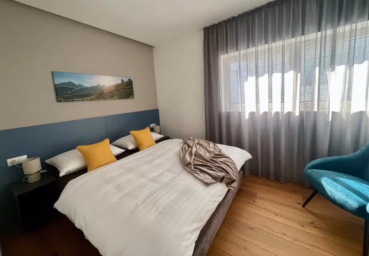 Schlafzimmer mit Doppelbett und gelben Kissen