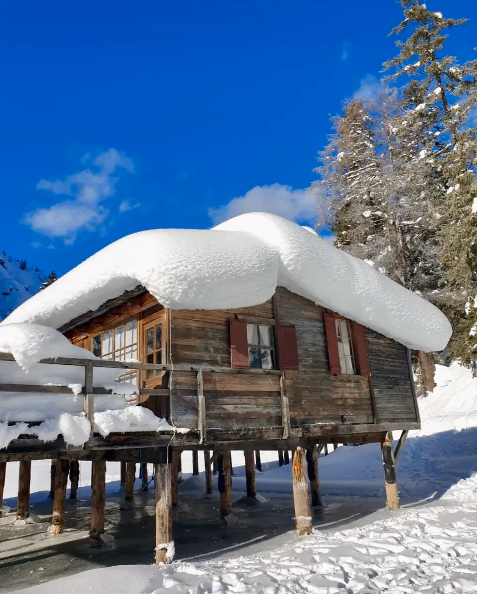 Tief verschneite Holzhütte