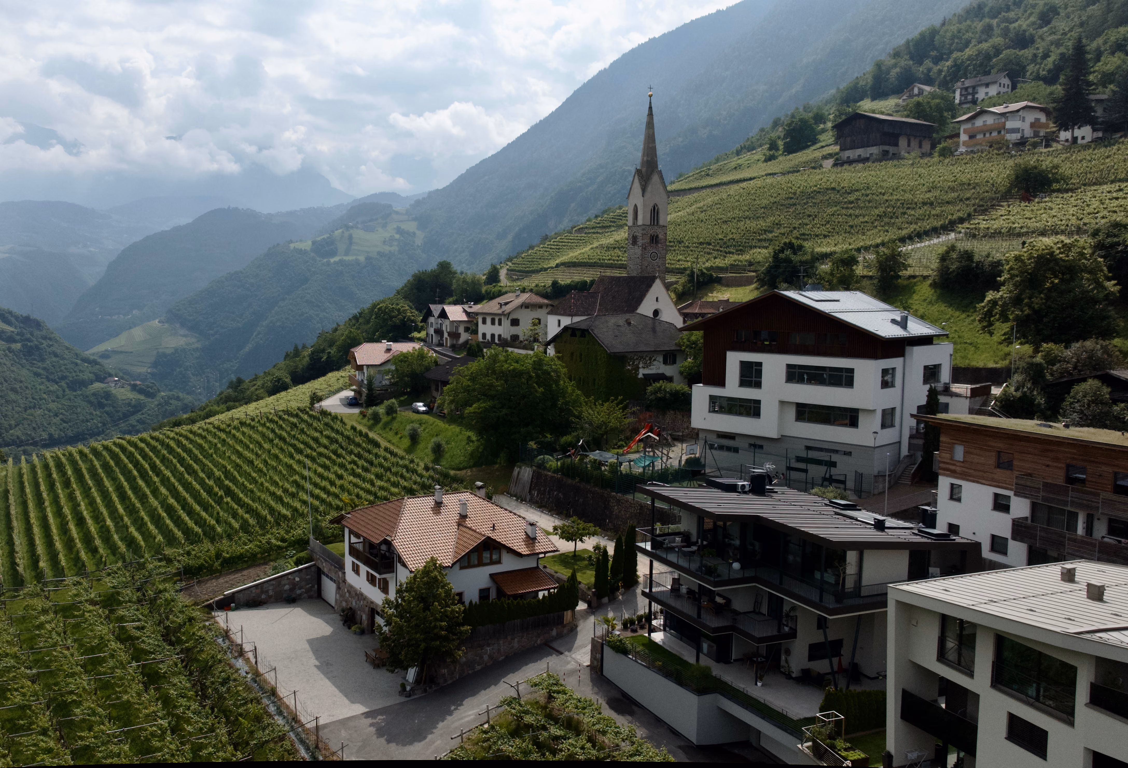 Luftaufnahme von Karneid mit Kirche und Weinbergen