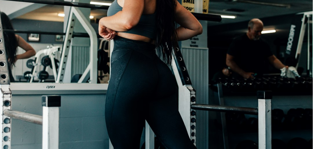 Interior of a gym with exercise equipment and people.