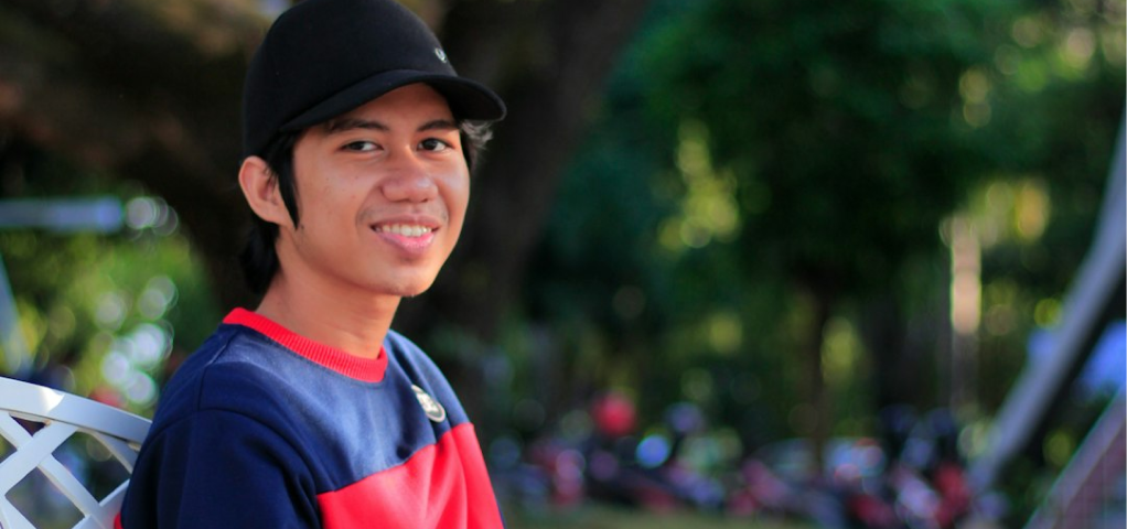 Grayscale photograph of a person smiling outdoors.