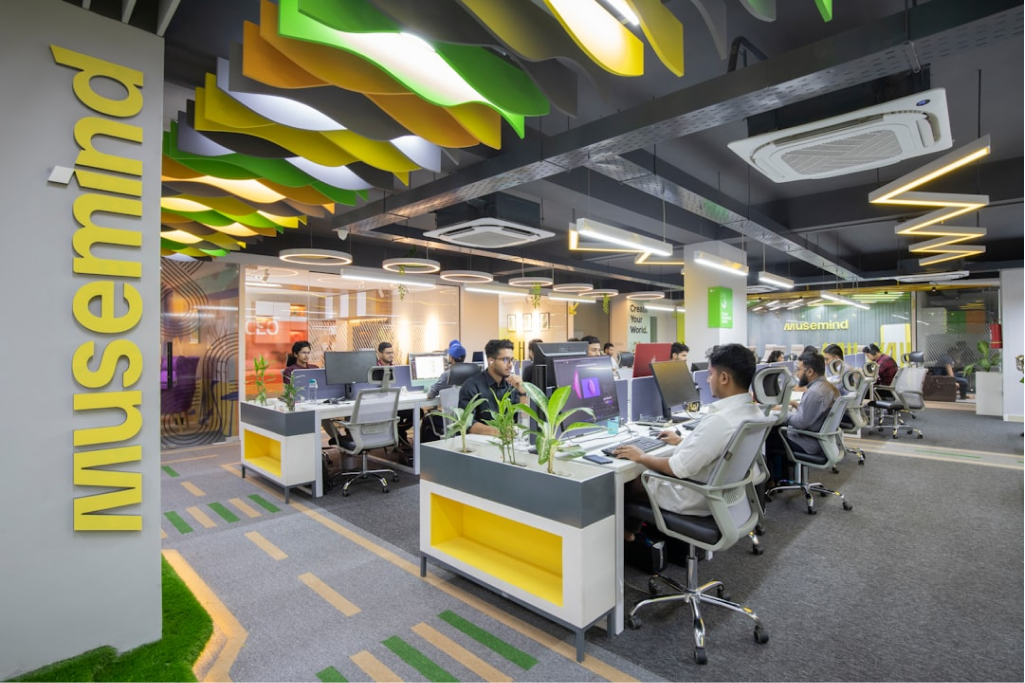Full-width image of a modern office interior with desks and chairs.