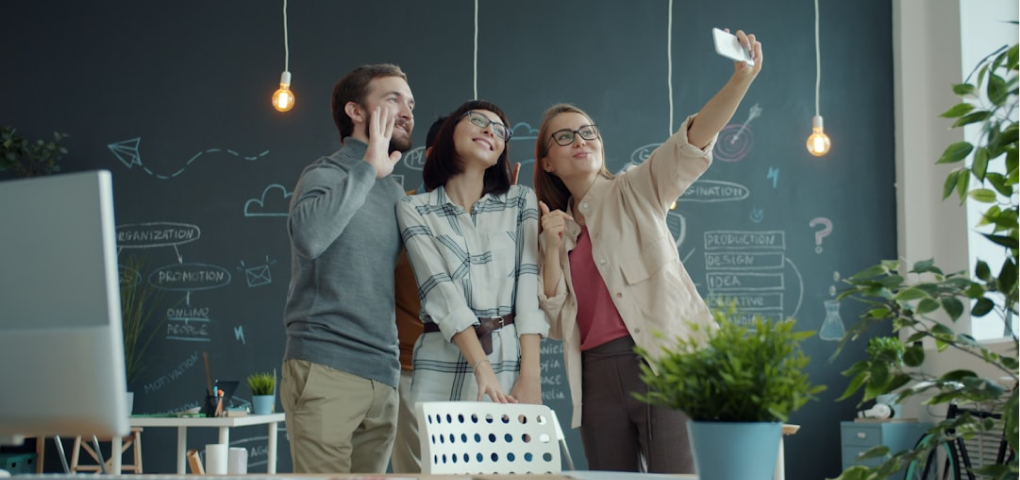 Image of three people posing for a selfie in an office setting.