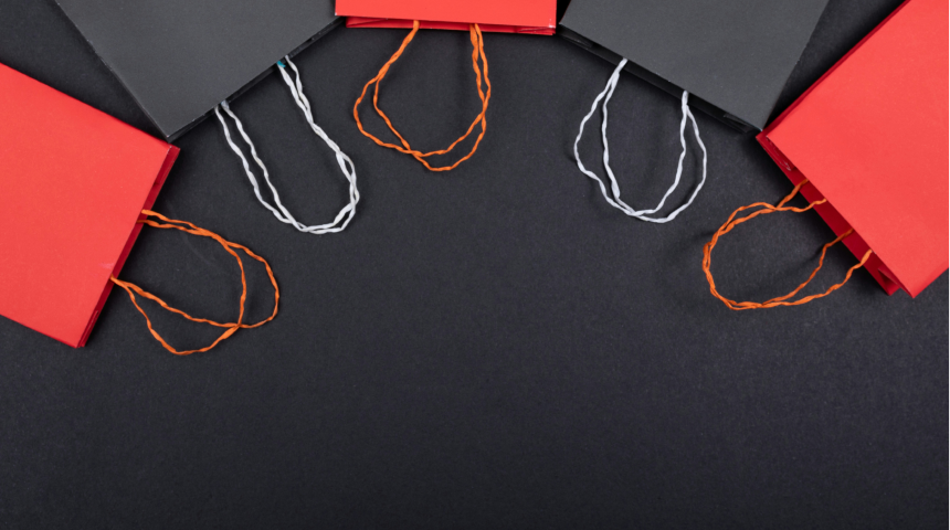 Overhead view of shopping bags with handles arranged in a curve.
