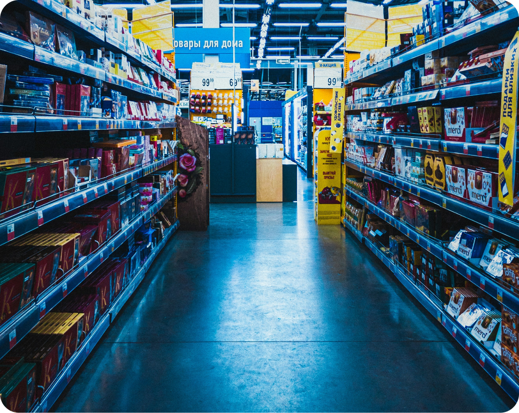 Grayscale photograph of a retail store aisle with shelves.