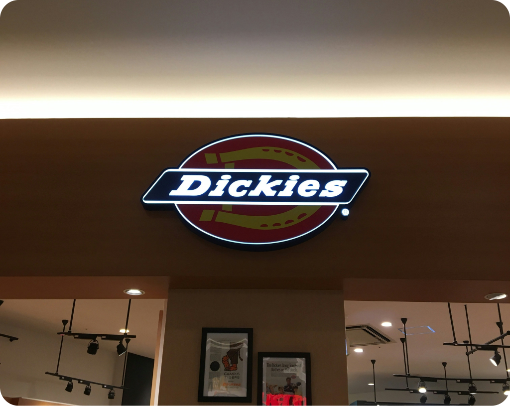 Company logo sign with text, displayed on a wall.