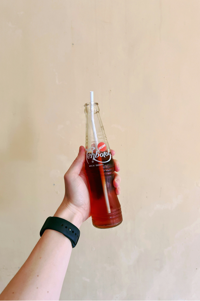 Black and white photograph of a person holding a glass bottle.