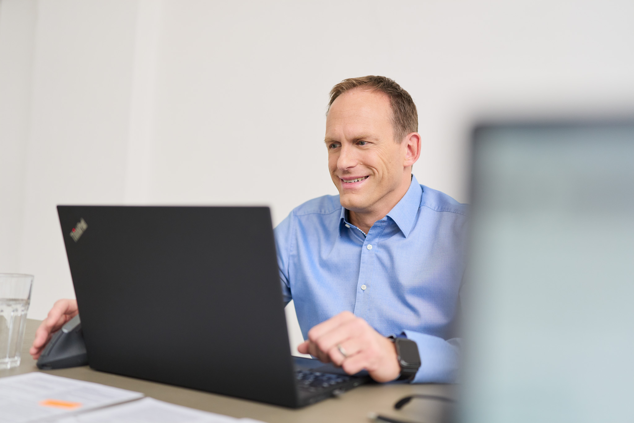 Ein Mitarbeiter von loyos bi sitzt am Laptop und lächelt.