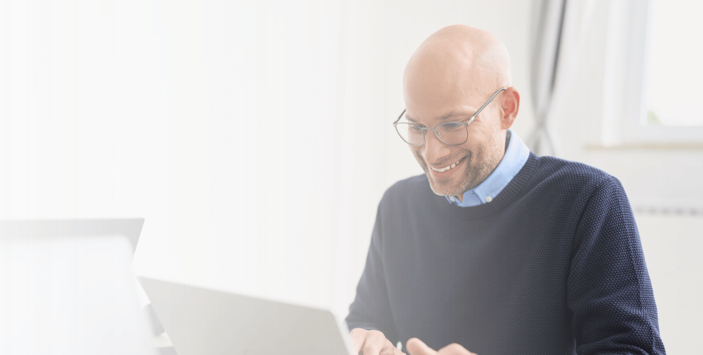 Ein Mann sitzt am Laptop, auf dem Bild ist ein weißer Schleier.